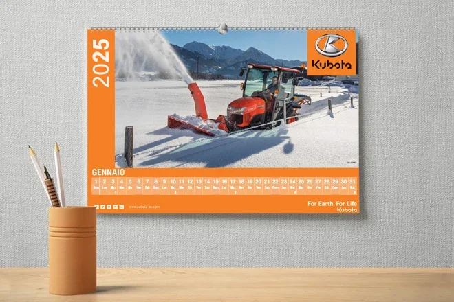 Calendario da parete del 2025 con un trattore Kubota che sgombera la neve, con la scritta GENNAIO (gennaio) in basso e il logo Kubota in alto a destra.