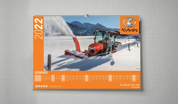 Un trattore Kubota con un accessorio spazzaneve sgombera la neve in una fattoria in una zona montuosa, in una pagina del calendario di gennaio 2022.