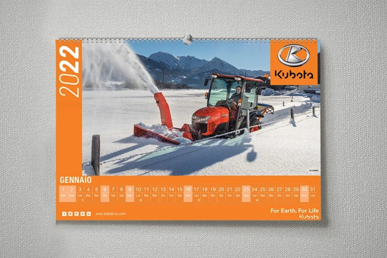 Un trattore Kubota con un accessorio spazzaneve sgombera la neve in una fattoria in una zona montuosa, in una pagina del calendario di gennaio 2022.