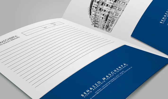 Libretto aperto con copertina blu con marchio "BENAZZO MASCHERRA" e pagine a righe; uno schizzo dell'edificio in bianco e nero appare nell'angolo superiore destro della pagina interna.