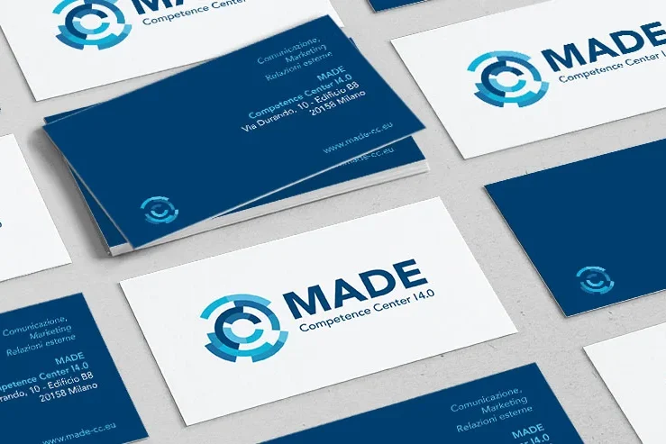 I biglietti da visita del MADE Competence Center I4.0 sono disposti su una superficie, con il logo dell'azienda, il nome, i dati di contatto e una combinazione di colori blu e bianco.