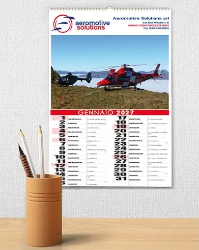 Calendario da parete per gennaio 2027 con un elicottero rosso e un elicottero nero su un paesaggio roccioso, con il marchio dell'azienda aeromotive solutions in alto.
